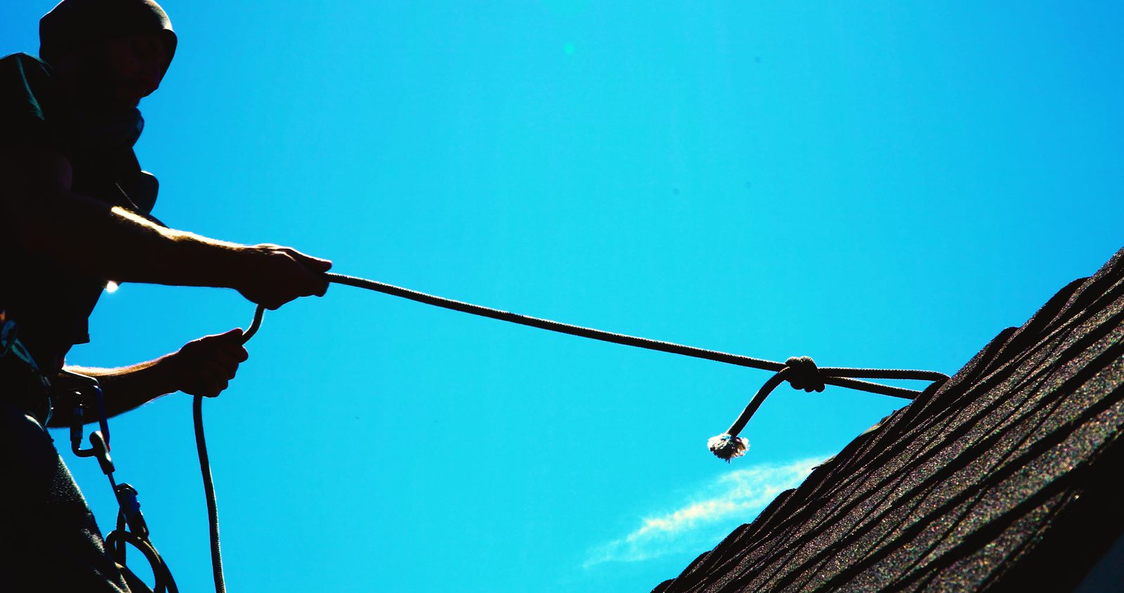JNR crew member roped off safely while working a steep Portland roof