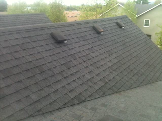 Same steep composition shingle roof after moss treatment, clean and uniform