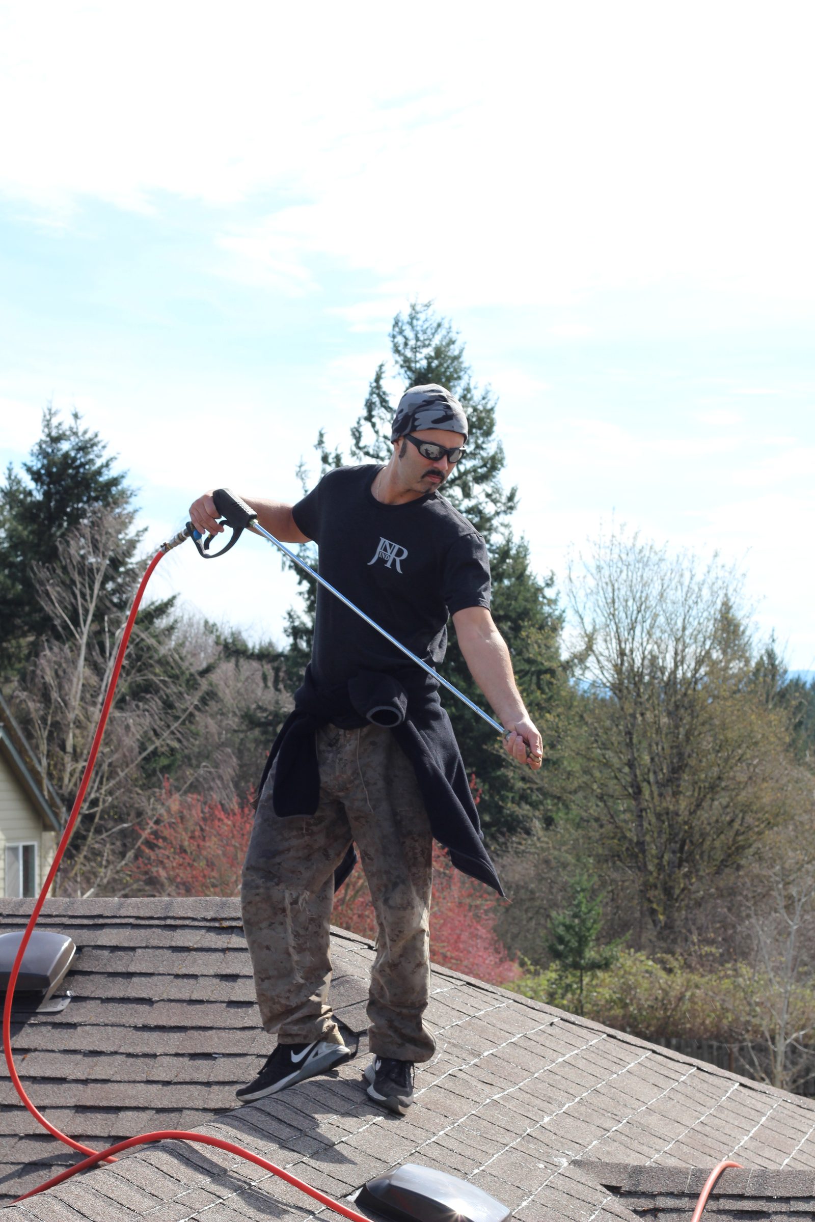 Jesse Rice of JNR Industries pressure washing a Portland composition roof