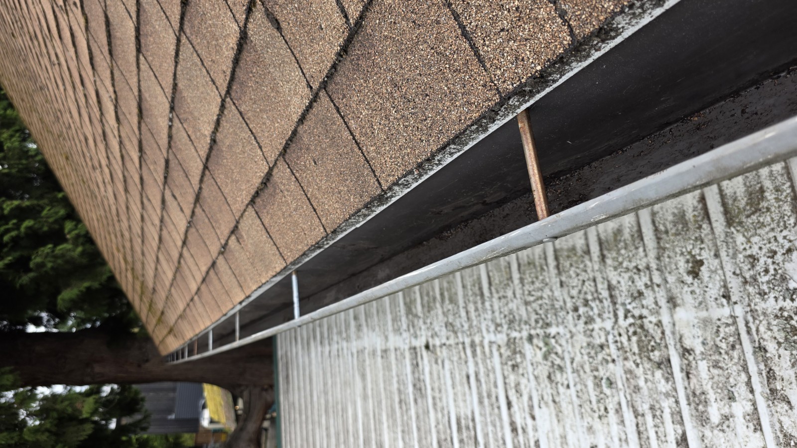 The same lower gutter cleared of weeds and debris, after cleaning