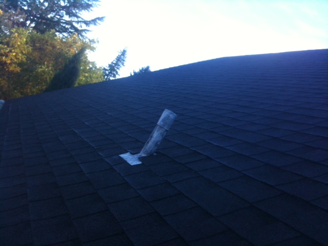 Clean dark composition shingle roof with a single vent pipe, steep pitch
